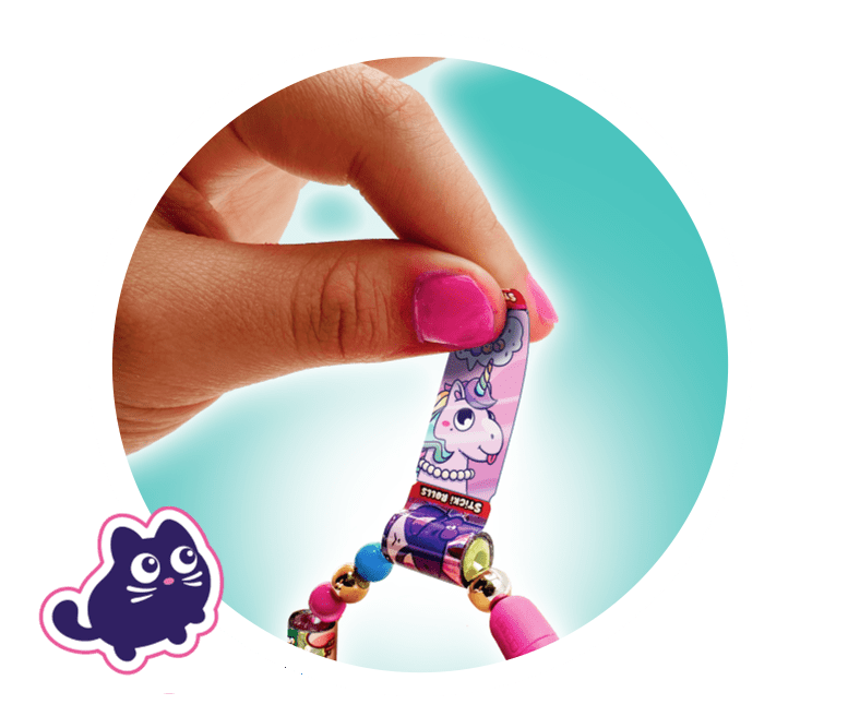 Fingers holding a unicorn sticker design.